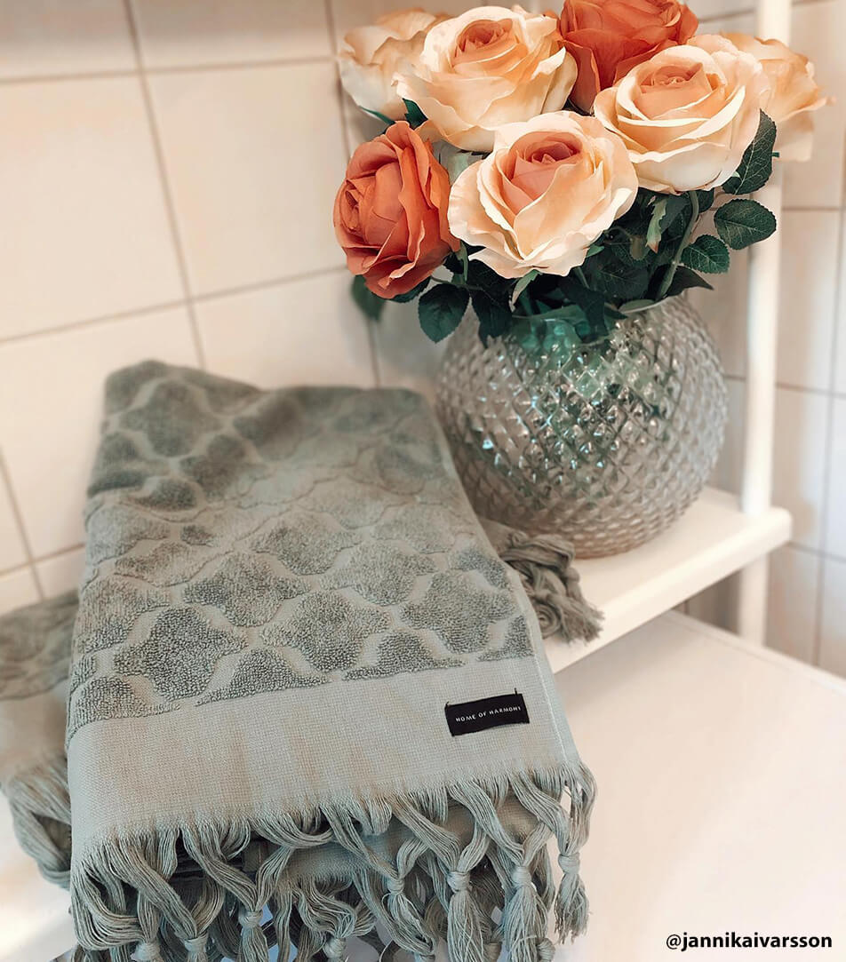 Harmaat pyyhkeet skandinaaviseen valkoiseen kylpyhuoneeseen