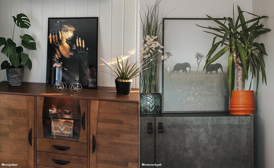 Taulut ja kasvit piirongin päälle aseteltuina